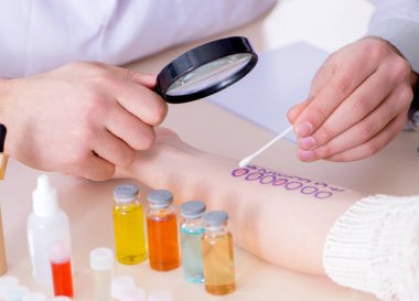 Hastanedeki hastanın alerji reaksiyonunu test eden doktor.