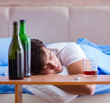 Yatakta içen alkolik adam depresyona giriyor.