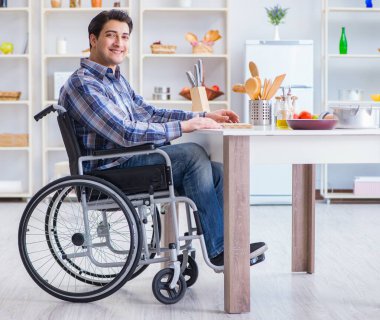 Engelli genç koca mutfakta çalışıyor.