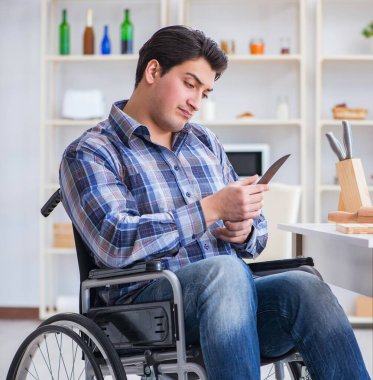 Engelli genç koca mutfakta çalışıyor.