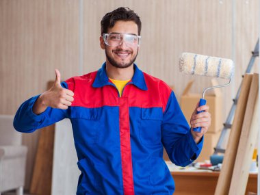 Yooung marangoz boyayla uğraşıyor.