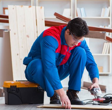 Genç marangoz ahşap kalaslarla çalışıyor.