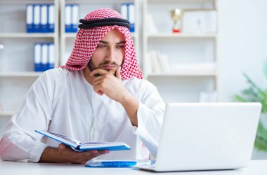 Ofiste çalışan Arap işadamı bir Pi ile evrak işi yapıyor.