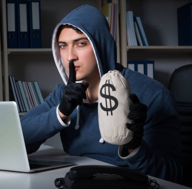 Genç hacker geceleri bilgisayarı hackliyor.