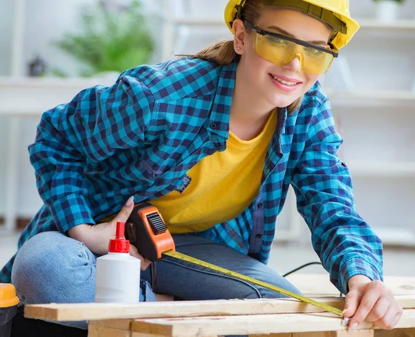 Female repairman carpenter cutting joining wooden planks doing r — Stock Photo, Image