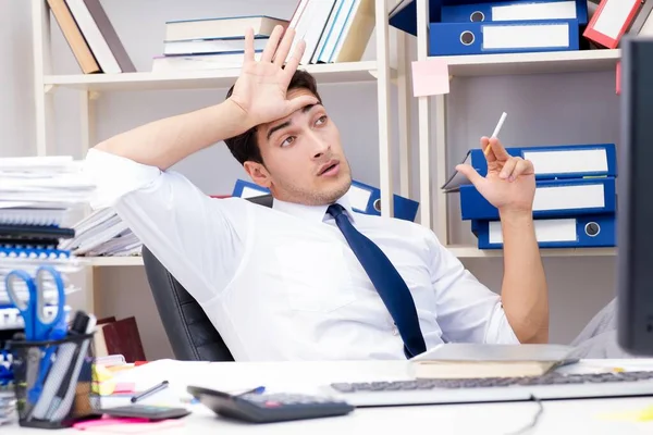 Homme d'affaires travaillant dans le bureau avec des piles de livres et de papiers — Photo