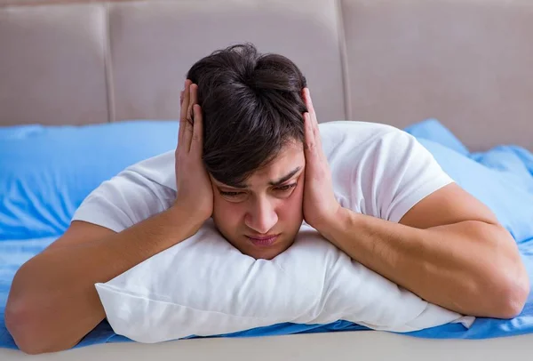 Hombre que sufre de insomnio acostado en la cama —  Fotos de Stock