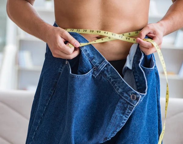Hombre en pantalones de gran tamaño en concepto de pérdida de peso — Foto de Stock