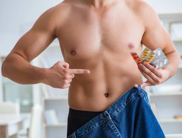 Hombre en pantalones de gran tamaño en concepto de pérdida de peso — Foto de Stock