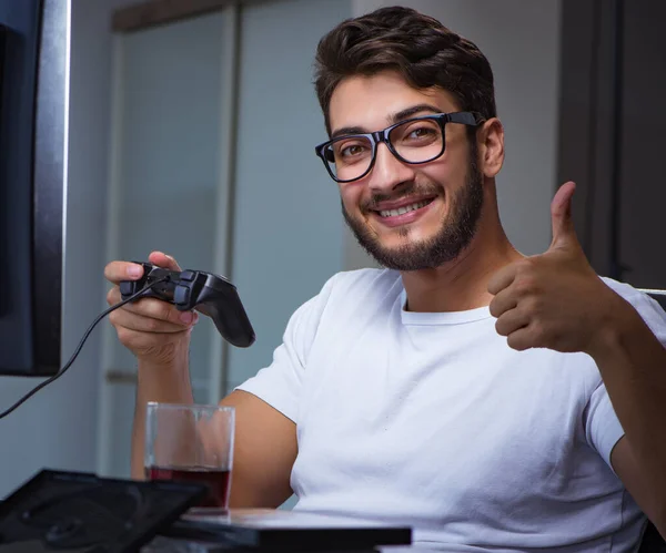 Jeune homme jouant à des jeux longues heures en retard au bureau — Photo