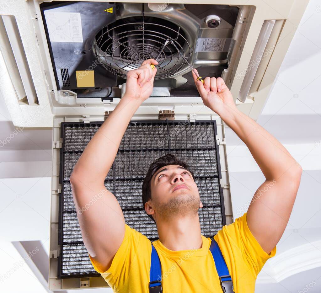 Repairman repairing ceiling air conditioning unit