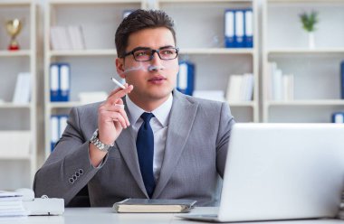 İşadamı ofisinde sigara içiyor.