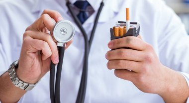 Sigara paketiyle sigara karşıtı bir erkek doktor.
