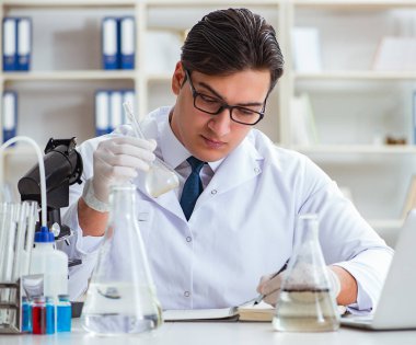 Genç araştırmacı bilim adamı bir su testi kirliliği araştırması yapıyor.