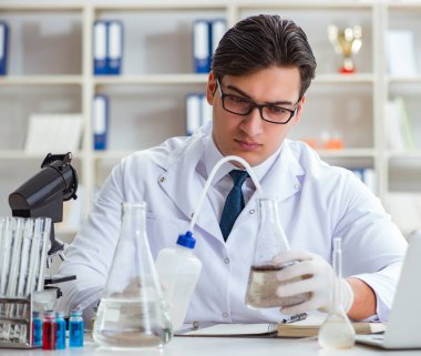 Genç araştırmacı bilim adamı bir su testi kirliliği araştırması yapıyor.