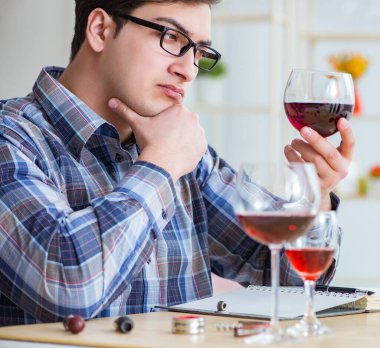 Profesyonel şarap garsonu kırmızı şarap tadıyor.