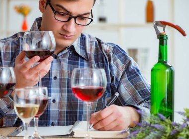 Profesyonel şarap garsonu kırmızı şarap tadıyor.