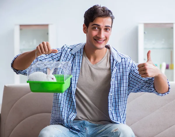 Junger Mann spielt zu Hause mit Kaninchen — Stockfoto