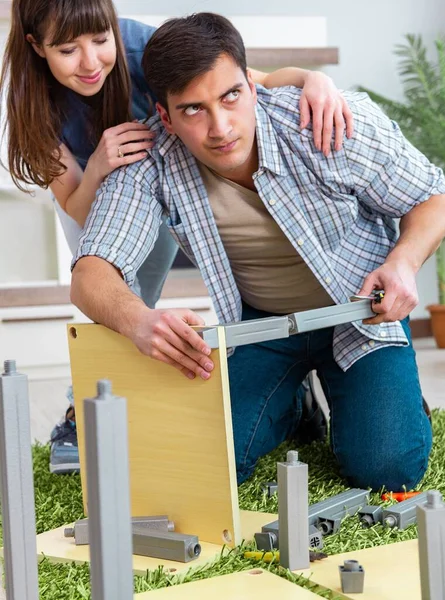 Ung familj montera möbler i nytt hus — Stockfoto