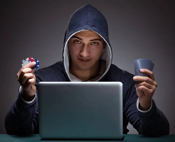Mladý muž v mikině sedící před laptopem — Stock fotografie