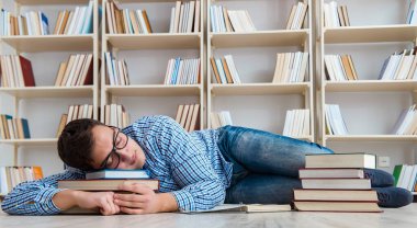 Genç öğrenci kitaplarla çalışıyor.