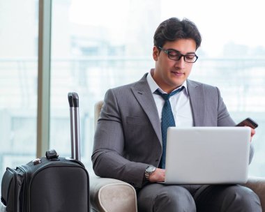 Havaalanındaki iş yerinde genç işadamı uçuş için bekliyor.