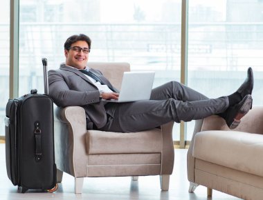 Havaalanındaki iş yerinde genç işadamı uçuş için bekliyor.