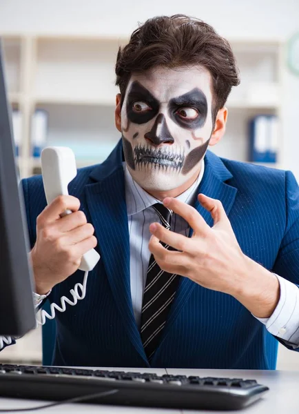 Businessmsn з страшною маскою для обличчя, що працює в офісі — стокове фото