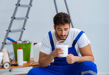 Tamirci, duvar kağıdıyla evde tadilat yapıyor.