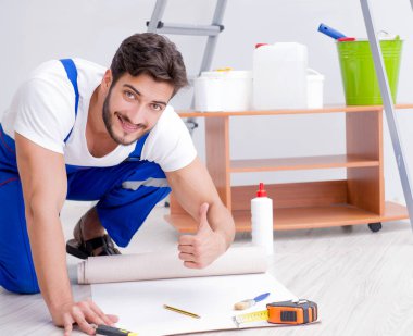 Adam evde duvar kâğıdı yenileme yapıyor.