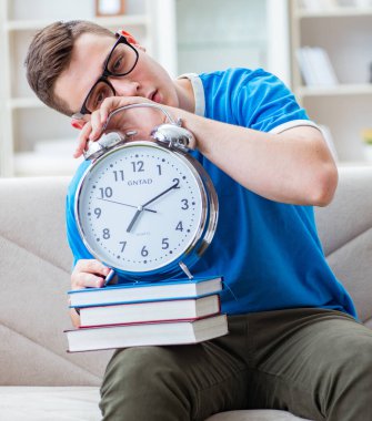 Sınavlara hazırlanan genç öğrenci kanepede ders çalışıyor.