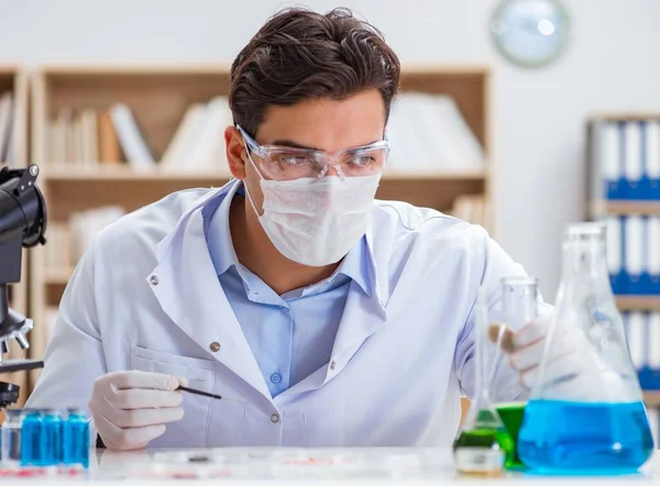 Laboratuvarda virüs aşısı üzerinde çalışan erkek doktor.