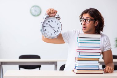 Sınıfta oturan genç erkek öğrenci.