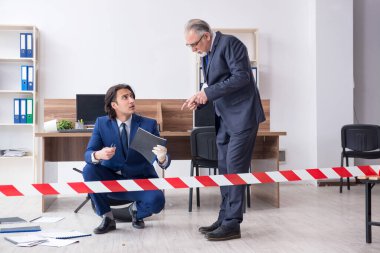 Ofiste çalışan iki kriminolog.