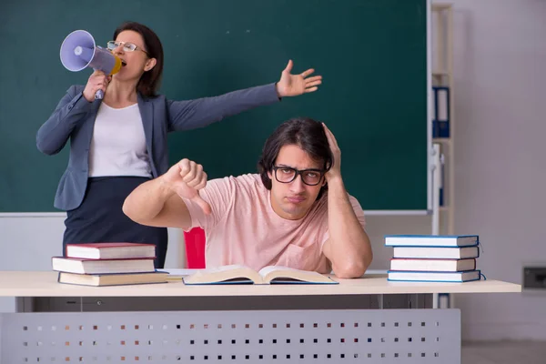 Gammal kvinnlig lärare och manlig student i klassrummet — Stockfoto