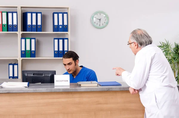 Two doctors talking at the reception in hospital — Stock Photo, Image