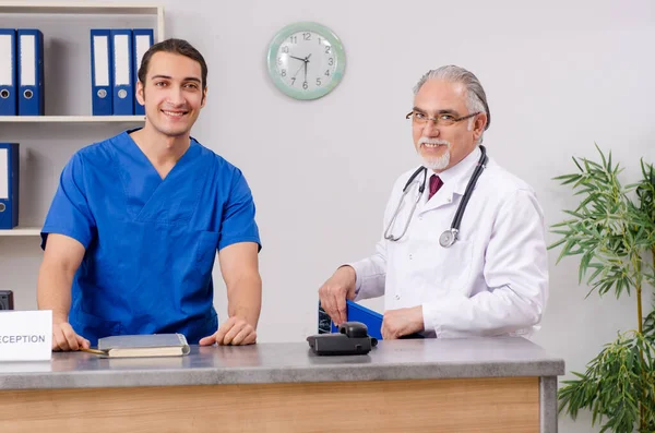 Two doctors talking at the reception in hospital — Stock Photo, Image