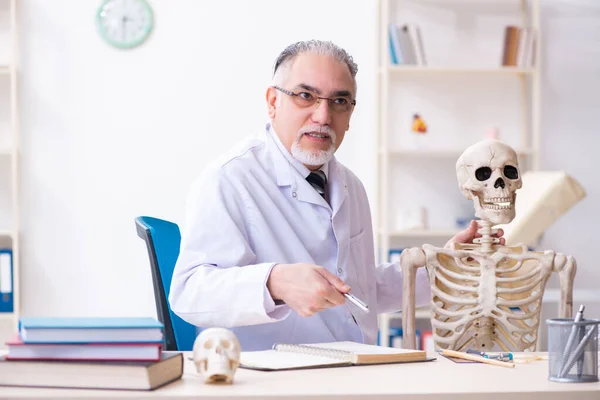 Médico varón envejecido con esqueleto —  Fotos de Stock