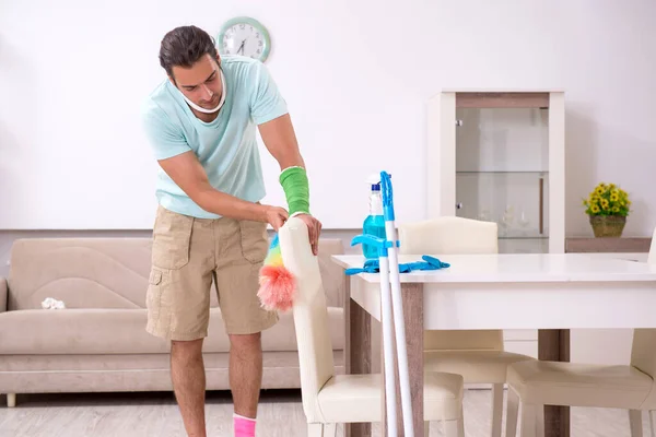 Jonge gewonde man die het huis schoonmaakt — Stockfoto