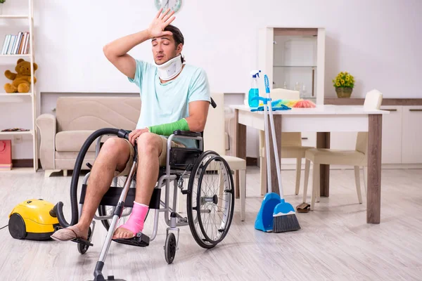 Junger Mann im Rollstuhl putzt das Haus — Stockfoto
