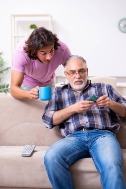 Genç öğrenci ve yaşlı büyükbabası evde.