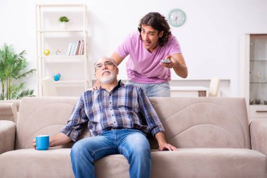 Genç öğrenci ve yaşlı büyükbabası evde.