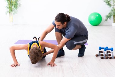 Genç baba ve oğlu egzersiz yapıyor.