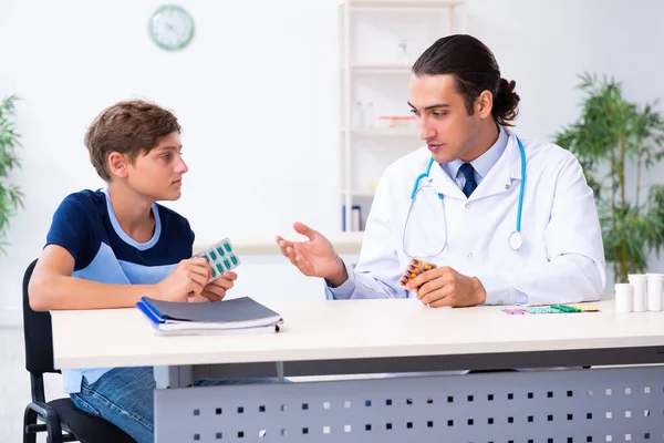 Young male doctor examining boy in the clinic — Stock Photo, Image
