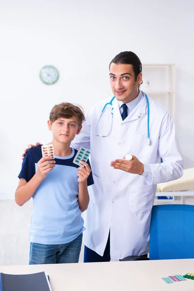 Jonge mannelijke arts onderzoeken jongen in de kliniek — Stockfoto