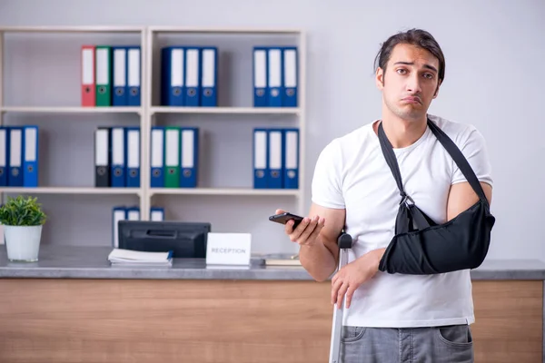 Young man at hospital reception desk — Stock Photo, Image
