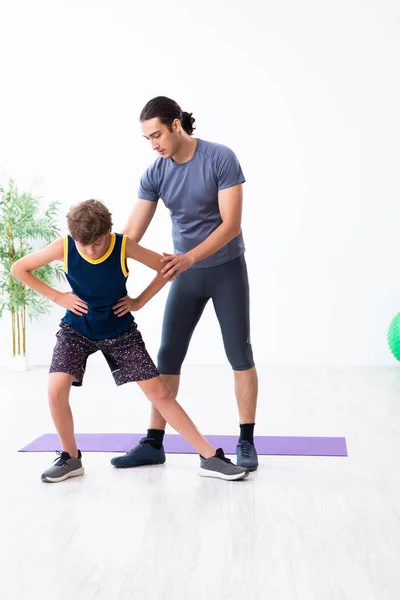 Jovem pai e seu filho fazendo exercícios — Fotografia de Stock