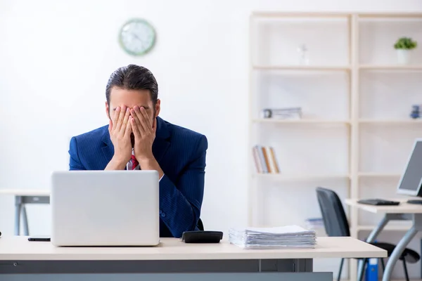 Jonge mannelijke zakenman zit in het kantoor — Stockfoto