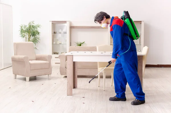 Joven contratista haciendo control de plagas en casa — Foto de Stock