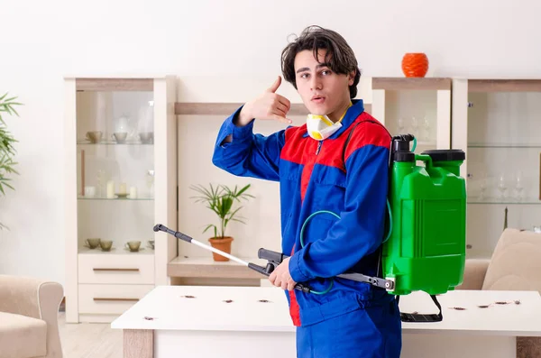 Jovem empreiteiro fazendo controle de pragas em casa — Fotografia de Stock